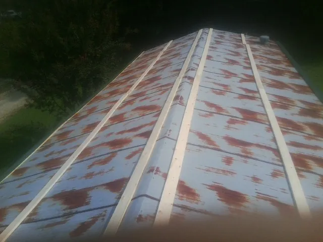 Rusted metal roof panels with new wood purlins before replacement — Storm Damage Roof Repair in Sun City Center by Roofing Brothers